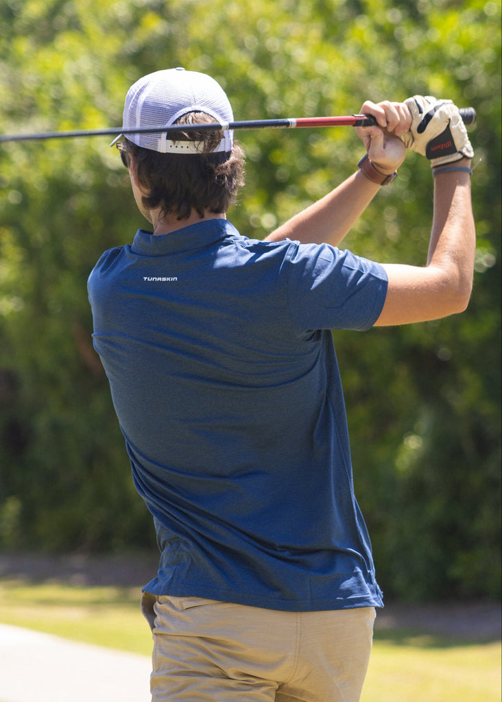 Man playing golf in navy Tunaskin polo