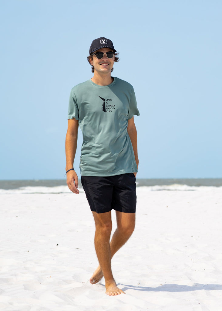 Man wearing olive Tunaskin shirt and black Tunaskin Surf Shorts