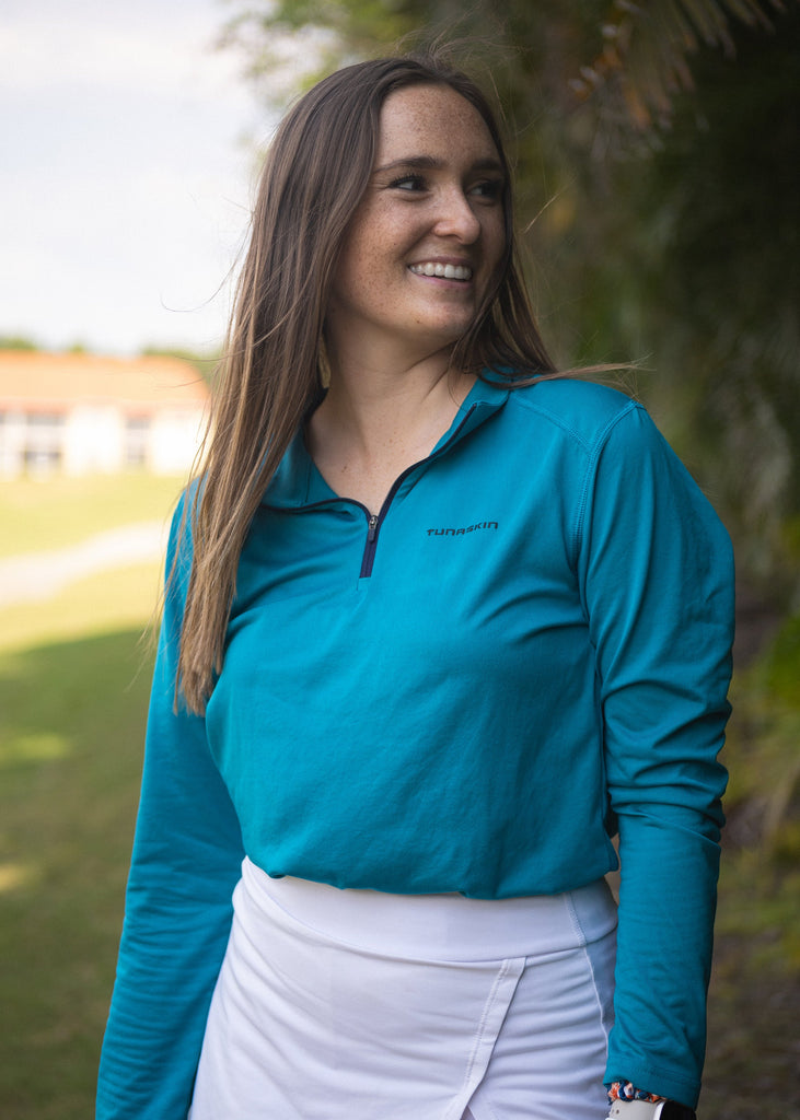 Woman wearing teal Tunaskin Quarter Zip