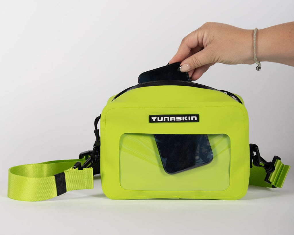 Hand holding a lime green Tunaskin crossbody board bag 